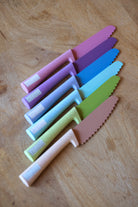 Set of colorful wheat straw  children knives on a wooden surface, Klyv classic knife for 3 years old Scandinavian Design 